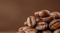 Macro shot of roasted coffee beans showing detailed texture and rich brown color against blurred background, highlighting natural grooves and patterns in beans.