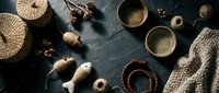 Cozy autumn flat lay with wicker baskets, ceramic bowls, knitted sweater and natural decorative elements on dark textured surface for seasonal home decor.