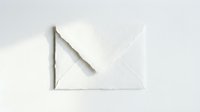 White handmade paper envelope with torn deckle edges on a light background, evoking elegance for wedding invitations and stationery.