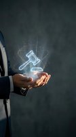 Businessman holding glowing digital gavel hologram representing legal technology, justice system innovation, and modern law practice solutions.