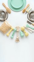 Flat lay arrangement of pet grooming and care supplies including mint green bowls, brushes, toys, and accessories on white background for pet care product marketing.