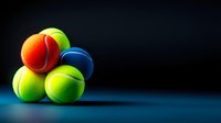 Colorful tennis balls stacked on blue surface against dark background, creating dynamic sports composition with vibrant yellow, orange and blue spheres.