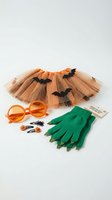 Halloween costume accessories set with orange tulle skirt, green monster gloves, bat decorations and orange sunglasses on white background.