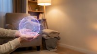 Person in beige sweater holding glowing purple energy sphere in cozy living room with warm lighting, suitable for technology, innovation, and future concepts.