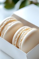White French macarons with creamy filling arranged in gift box. Delicate almond meringue cookies showcase smooth texture and elegant presentation for dessert menu.