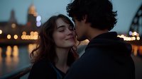 Young romantic couple embracing at twilight with city lights and waterfront in background, woman smiling with eyes closed as man kisses her cheek, creating intimate moment.
