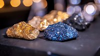 Sparkling mineral crystals in gold and blue colors on dark background with bokeh lights, natural gemstones showcase for jewelry design and luxury decor.