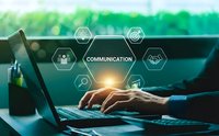 Business professional typing on laptop with digital communication network icons overlay representing modern workplace connectivity and collaboration technology.