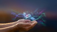 Cupped hands releasing magical glowing energy waves with colorful light trails and sparkles against dark gradient background for digital art projects.