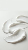 White cream texture smear on neutral background for skincare cosmetic product advertising and beauty industry marketing materials.