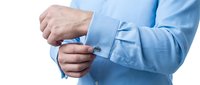 Caucasian male professional in light blue dress shirt adjusting cufflinks, formal business attire and elegance for corporate, executive, and professional occasions.