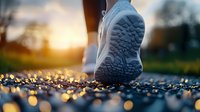 Close-up of athletic shoe sole on wet asphalt with golden sunset bokeh reflections, capturing morning jog atmosphere. For sports and lifestyle marketing.