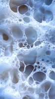 Abstract cellular structure in cool blue and white tones showing organic bubble-like formations and intricate network patterns, suitable for medical or scientific backgrounds.