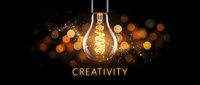 Glowing vintage lightbulb with golden bokeh lights and creativity text on dark background for inspiration and innovation concepts.