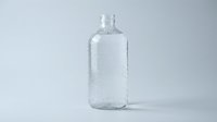Clear glass bottle with water droplets isolated on white background, suitable for beverage, cosmetic, and product packaging design mockups.