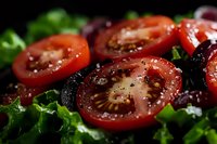 Fresh tomato slices with herbs and seasoning on dark surface. Healthy cooking ingredients for salads, Mediterranean cuisine and organic food preparation.
