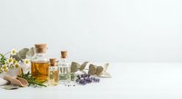 Natural aromatherapy essential oils in glass bottles with cork stoppers, fresh herbs and flowers for spa wellness treatments and holistic healing.
