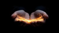 Glowing magical light sparkles floating above cupped hands against dark background, creating mystical energy effect for spiritual and fantasy designs.