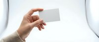 Hand holding blank white business card against white background, isolated for corporate branding and design mockup purposes.