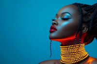 Young woman with braided hair and gold beaded choker necklace in dramatic lighting against blue background, wearing bright red lipstick and vibrant eye makeup in artistic portrait.