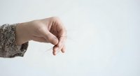 Woman hand in knitted sweater sleeve reaching out with gentle gesture against clean white background for design projects.
