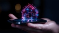 Glowing holographic house floating above smartphone in dark environment with sparkles and light effects, representing smart home technology and digital real estate.