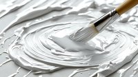 White acrylic paint texture with brush creating swirling patterns on canvas, thick impasto technique showing rich textural detail and artistic process in progress.