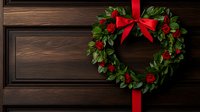 Heart shaped wreath with red roses and satin bow hanging on dark wooden door background, romantic holiday decoration for Valentine's Day or Christmas celebration.
