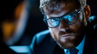 Dramatic portrait of beardedAted by intense blue light, creating mysterious cinematic atmosphere. Dark moody background adds depth.