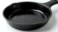Cast iron skillet pan for cooking and frying food in kitchen, black cookware utensil isolated on white background ready for culinary preparation and recipes.