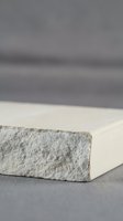 Minimalist white stone block on neutral surface with soft shadows and blurred background for product display and modern design concepts.