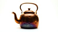 Copper kettle with rainbow iridescent finish isolated on white background for kitchen design and culinary projects.
