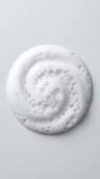 White foamy cleanser swirl with bubbles on light background for skincare and beauty product advertising and cosmetic packaging design.
