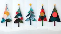 Paper cut Christmas trees with geometric shapes and decorative elements in modern minimalist style on white background. Handmade holiday craft design.