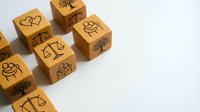 Wooden cubes with hand-drawn icons including hearts, smiling faces, and decorative symbols arranged on white background for creative projects and design work.