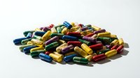 Colorful pharmaceutical capsules and pills scattered on white background. Medical supplements, vitamins, and medication for healthcare treatment.