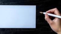Female hand holding white pen over blank paper on dark textured background, ready for writing or drawing. Minimalist composition for business or education concept.