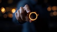 Glowing golden ring floating above hand with magical light effects and bokeh background creates mystical atmosphere for fantasy and magical concept designs.
