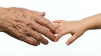 Elderly wrinkled hand gently holding young smooth hand showing intergenerational connection, care and support between generations on white background.