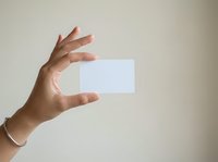 Male hand holding blank white card against neutral background, suitable for business presentations, marketing materials, and corporate branding mockups.