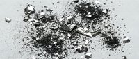 Crushed charcoal and ash scattered on white surface, suitable for artistic backgrounds, design elements, and creative projects.