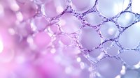 Macro view of delicate soap bubble foam structure in pink and purple gradient colors creating abstract geometric pattern with soft bokeh effect and light reflections.