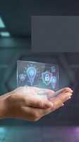 Hand holding holographic cybersecurity interface with lightbulb and shield icons representing digital protection and innovation in modern technology.