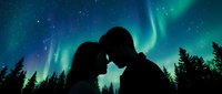 Silhouetted couple touching foreheads under vibrant green and blue aurora borealis dancing across starry night sky above evergreen forest landscape for romantic and nature themes.