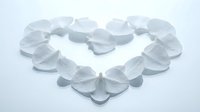 White rose petals arranged in romantic heart shape on clean background for wedding and love concepts.
