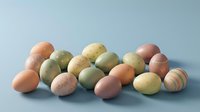 Colorful Easter eggs in pastel shades scattered on blue background for spring holiday celebration and festive decoration projects.
