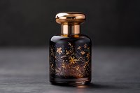 Luxurious black glass perfume bottle with gold floral pattern and copper cap on dark background. Elegant fragrance container for cosmetic and beauty industry.
