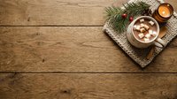 Hot chocolate with marshmallows on rustic wooden table with evergreen branches, festive holiday beverage flat lay for seasonal marketing and winter celebrations.