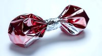 Crumpled red and silver metallic foil wrapper twisted in middle creating bow shape against white background, isolated product packaging detail for design use.