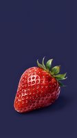 Fresh ripe strawberry with green leaves on dark blue background for healthy eating and nutrition concepts.